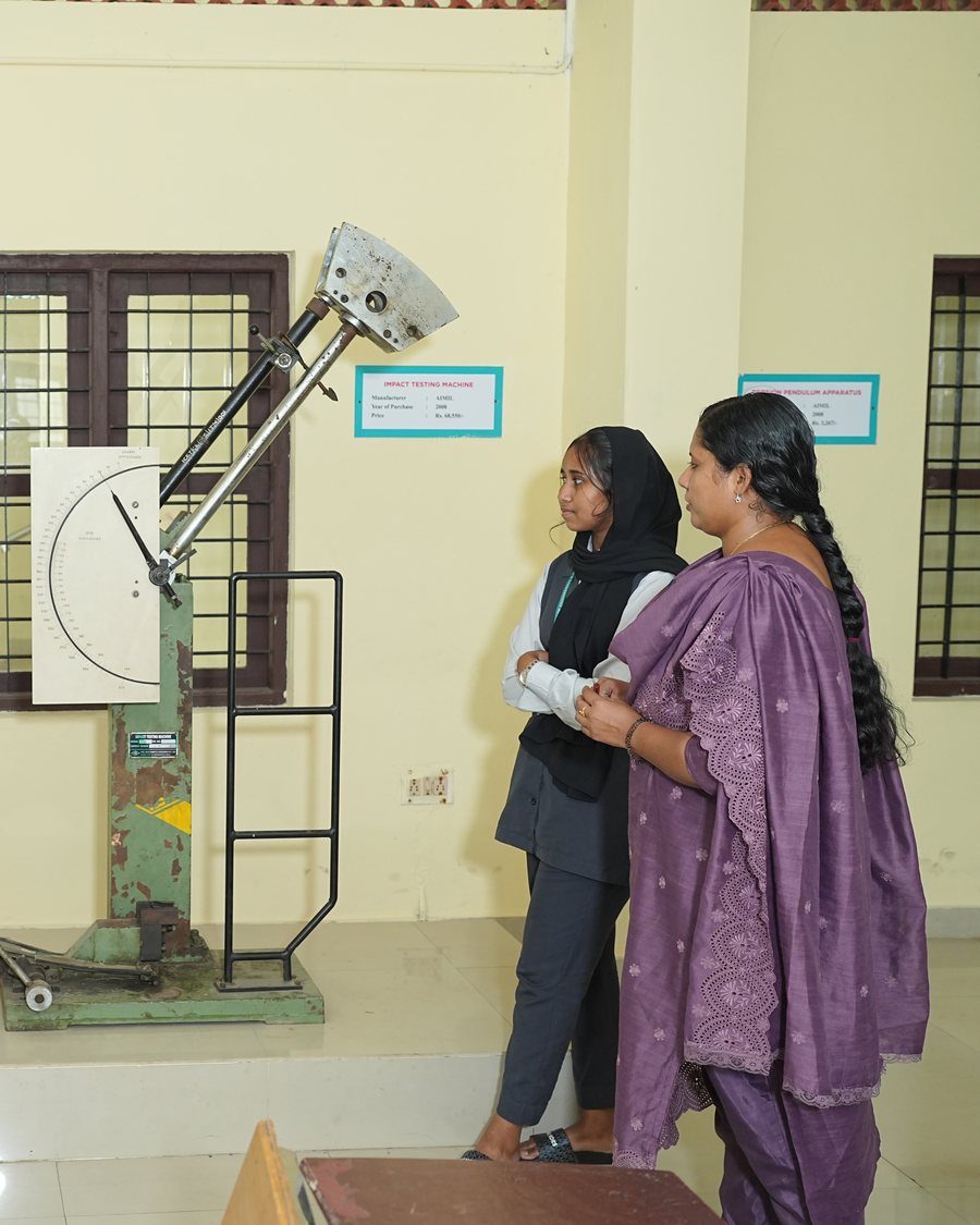 ICET students and a faculty member at an impact-testing machine in the mechanical engineering lab